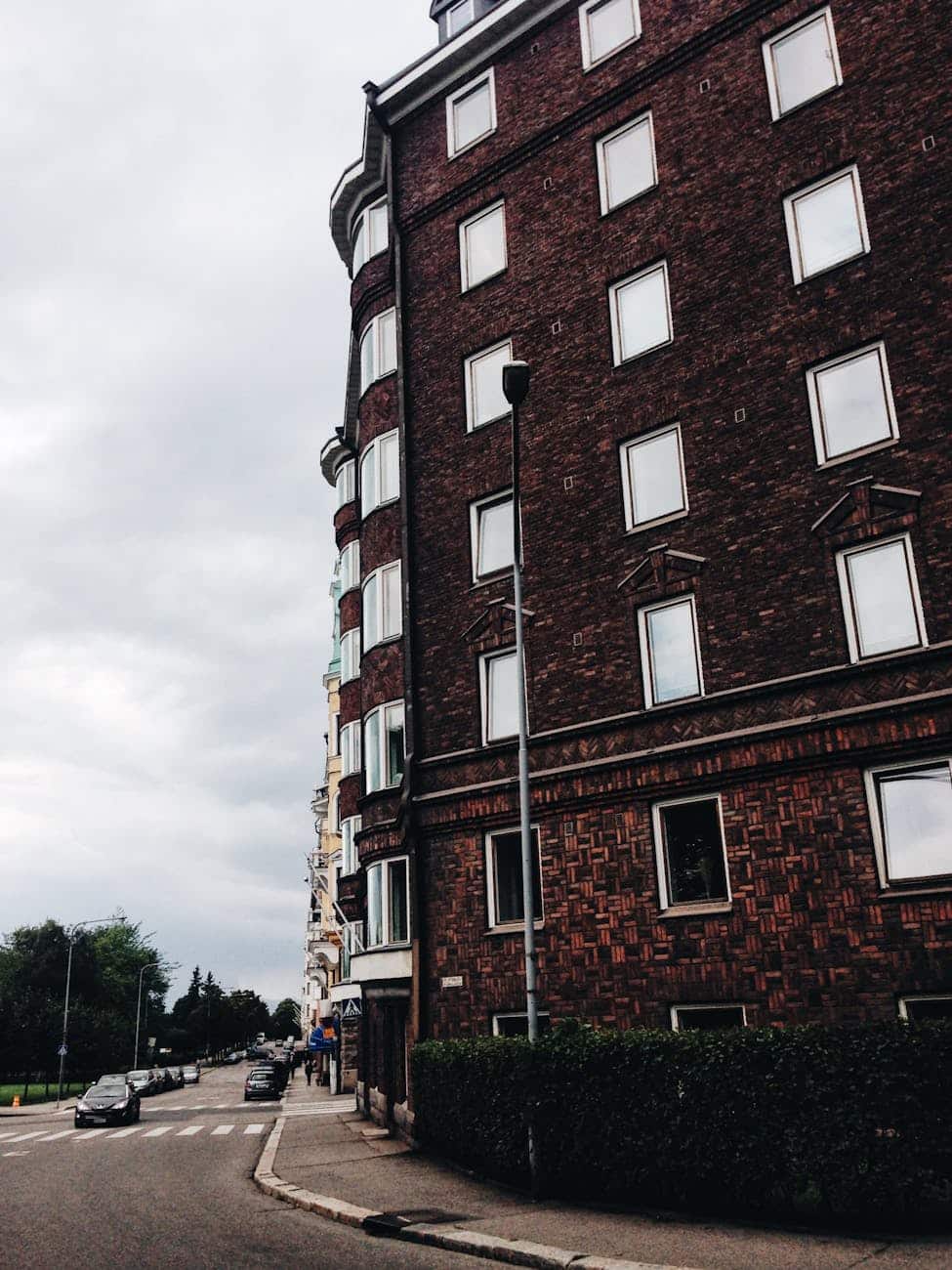 A quaint city scene featuring a historic brick apartment building on a cloudy day.
