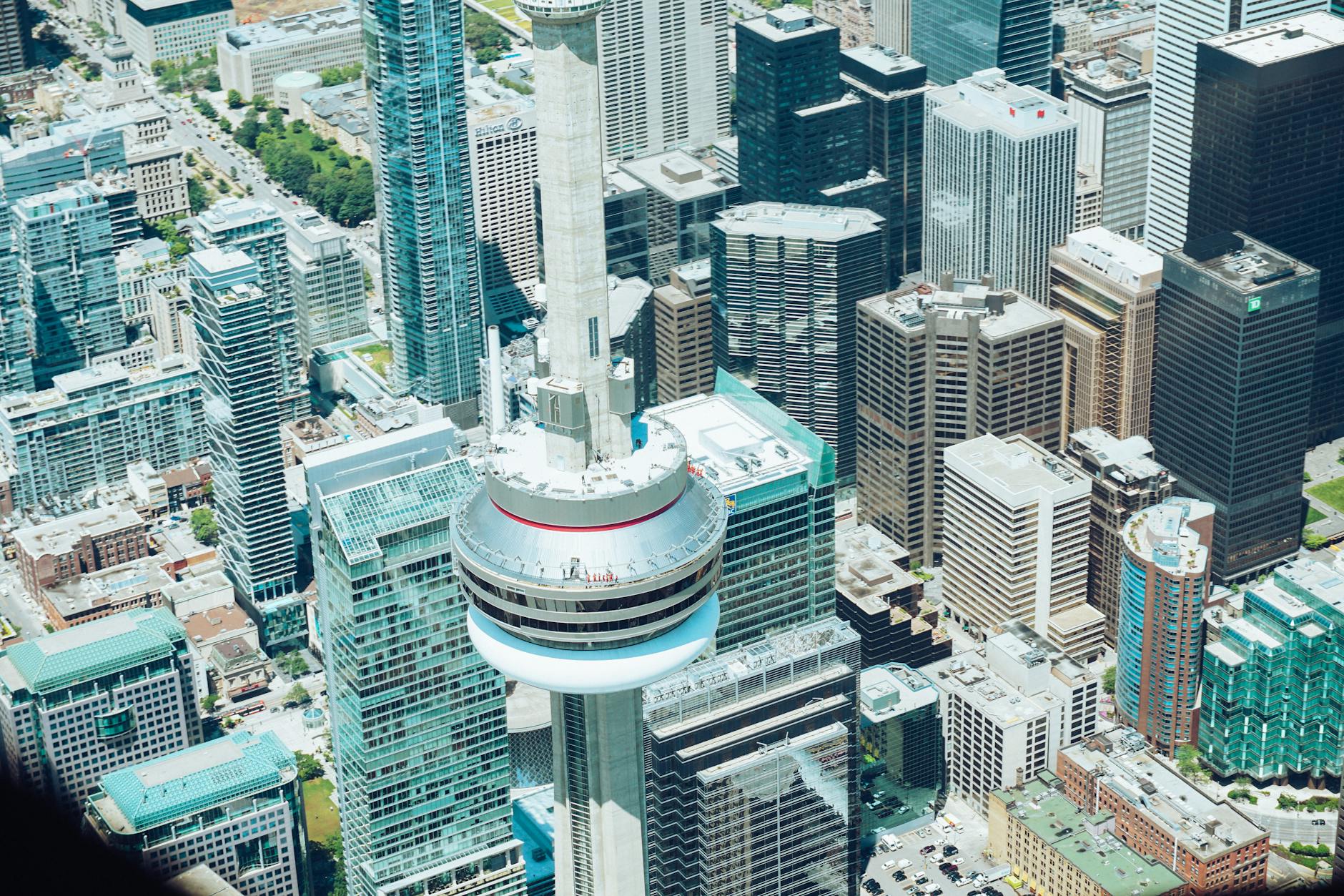 Stunning aerial view of CN Tower surrounded by skyscrapers in downtown Toronto.