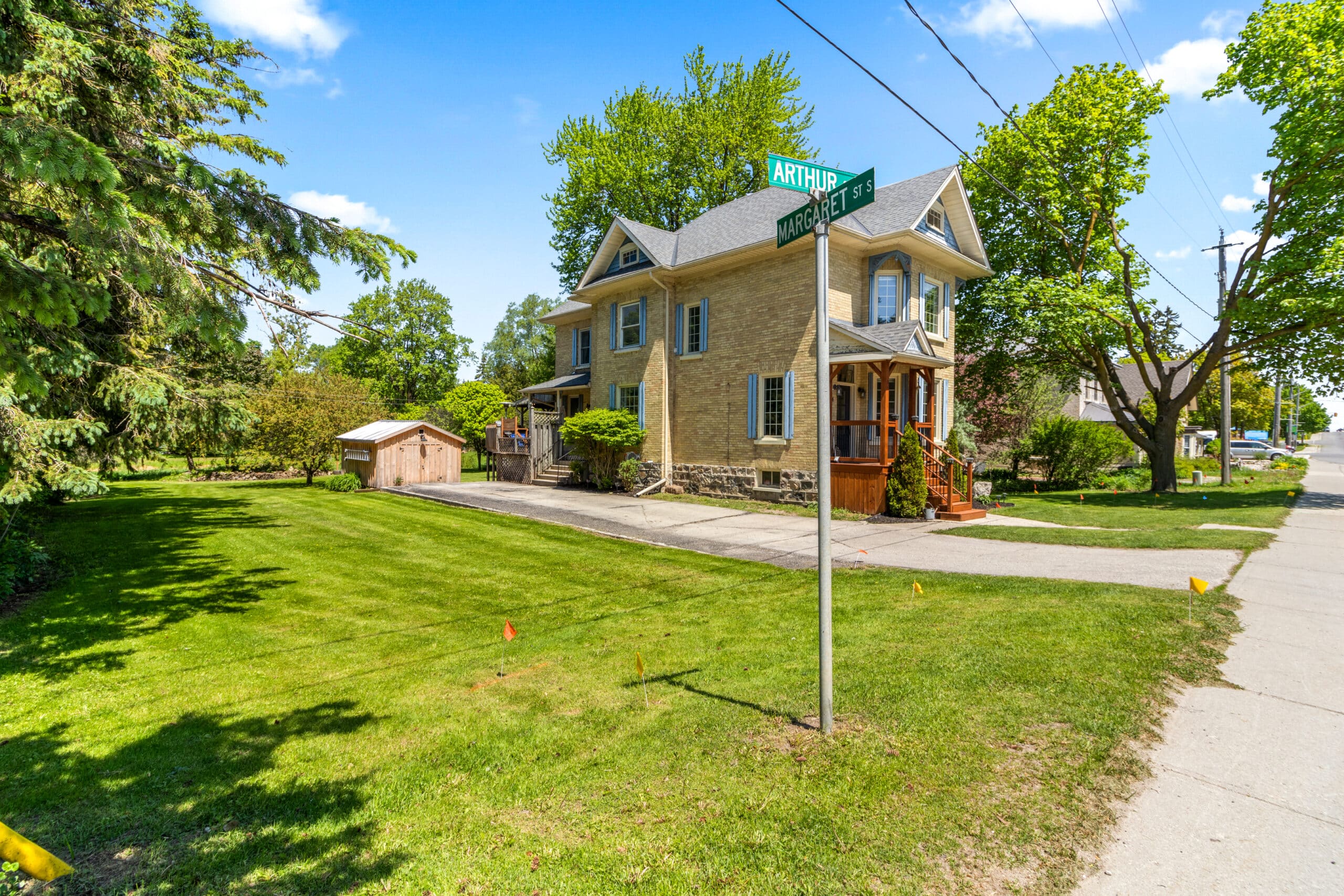 Two-story house with a stone exterior on a sunny day, located at the corner of Arthur St and Morris St, with a large lawn and trees.