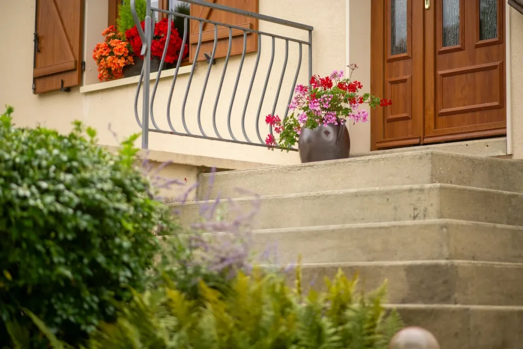 A charming front porch adorned with colorful flowers and a wooden door, reflecting the appeal of West Grey real estate.