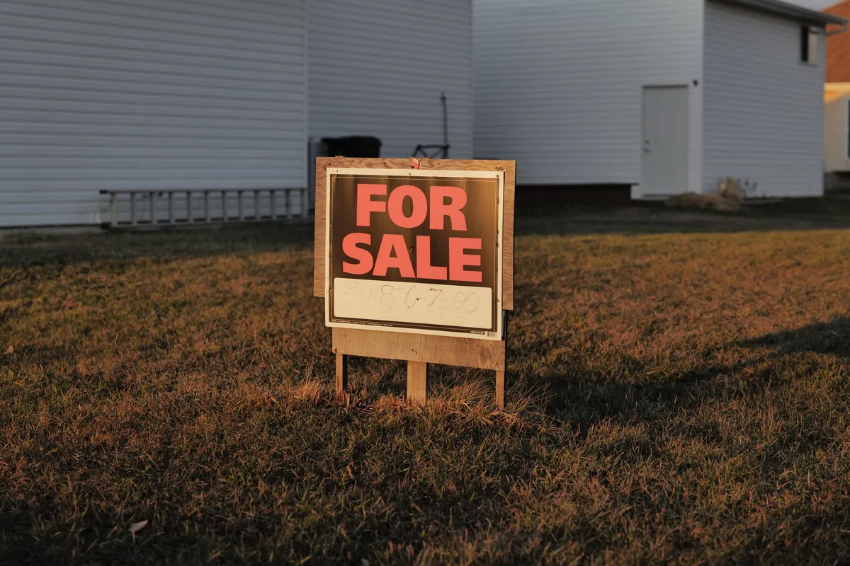 A property sign displaying a for sale message, highlighting real estate pricing variations.